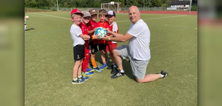 Die Kinder übergeben einen fair gehandelten Fußball an Thomas Gommert