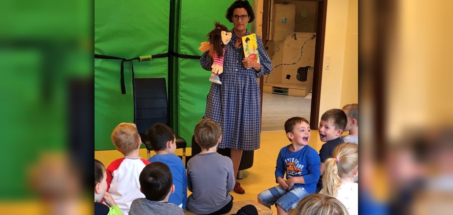 Kindergartenkinder lauschen Autorin Stephanie Gessner und ihre Handpuppe Mia.