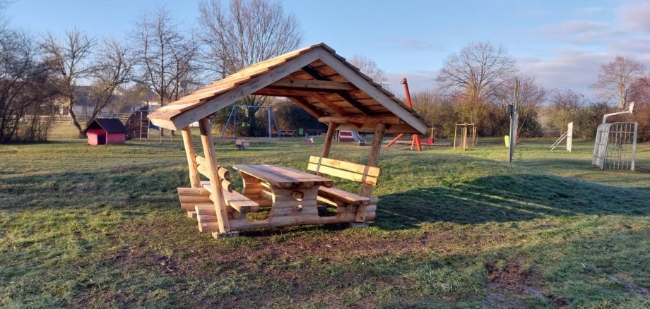 Eine überdachte Sitzgelegenheit auf einer Wiese