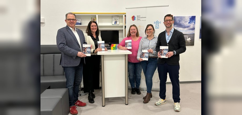 Gruppenfoto MGH-Team und Bürgermeister mit Programmheft in den Händen